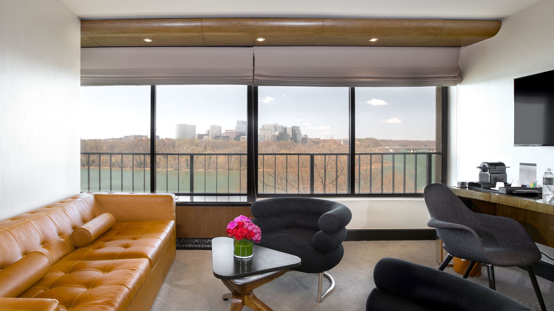 A Room With A Table Chairs And A Couch With A View Of The City