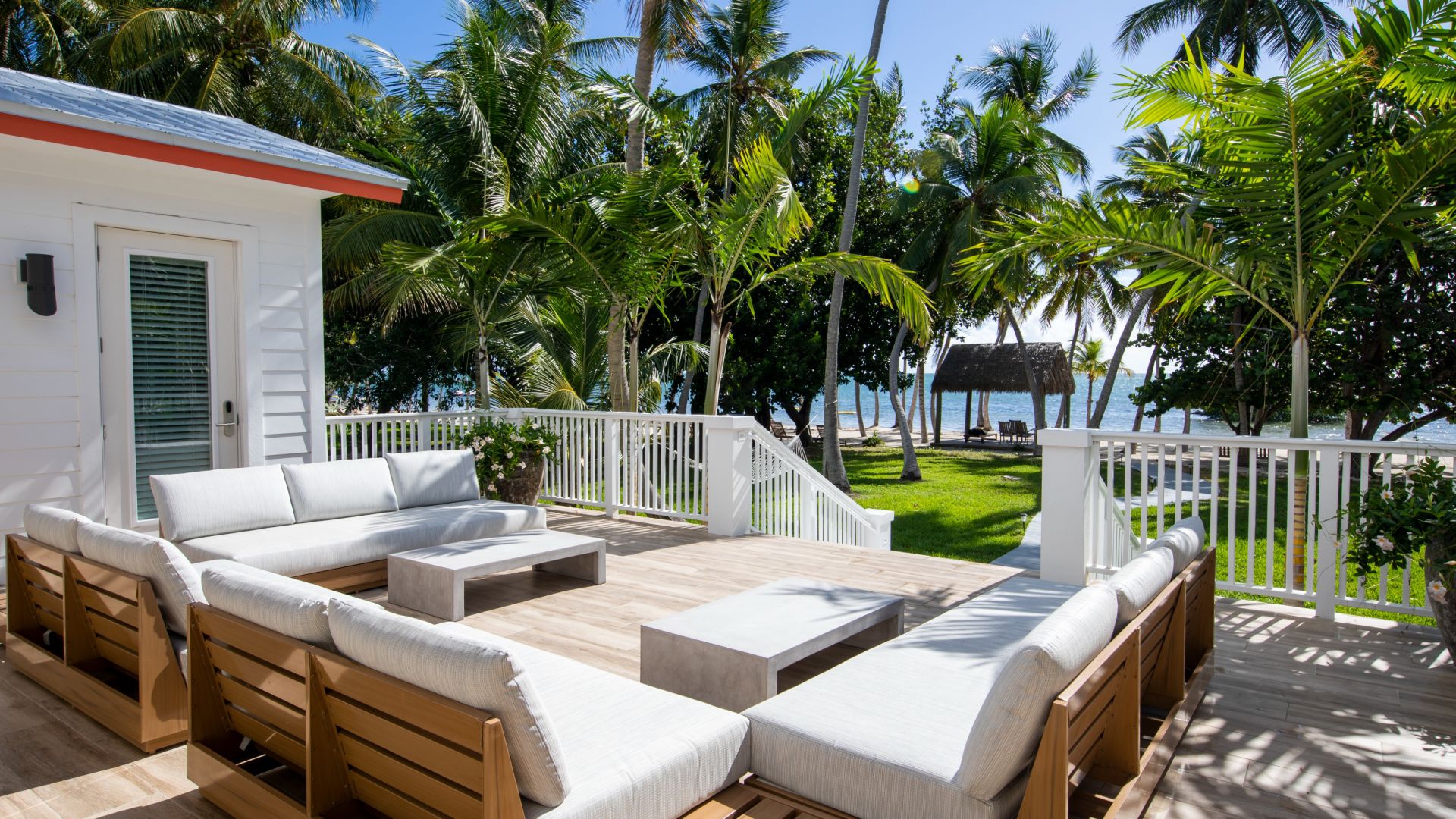 A Deck With A White Couch And Palm Trees