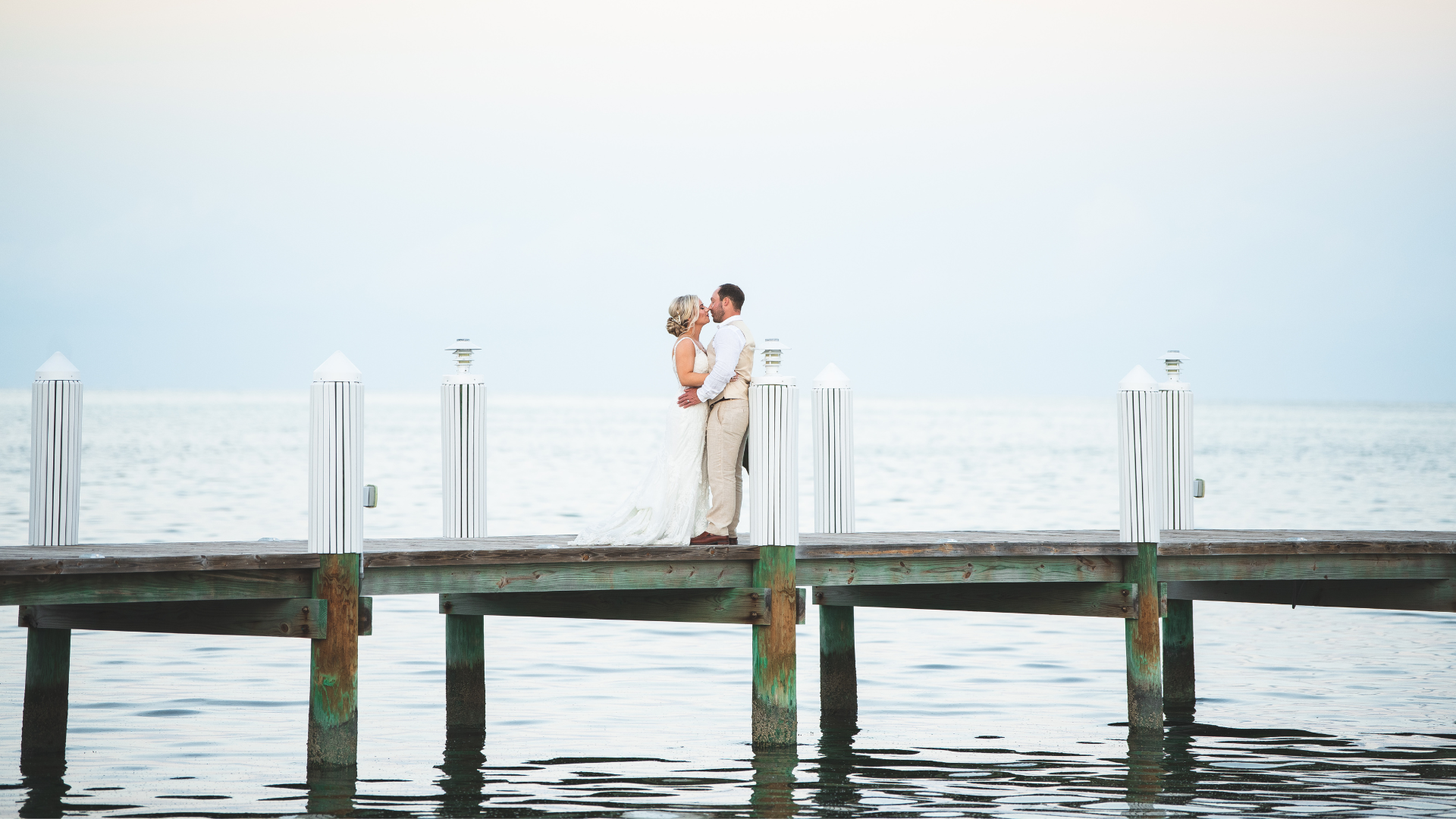 A Man And Woman Kissing On A Pier