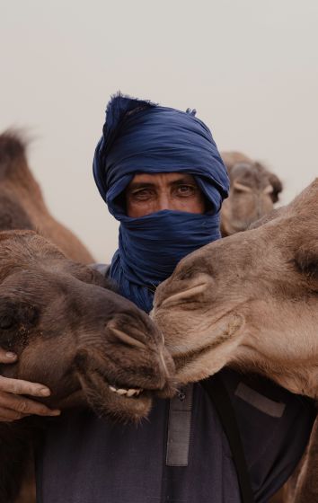 A Man With A Blue Face Paint And A Camel