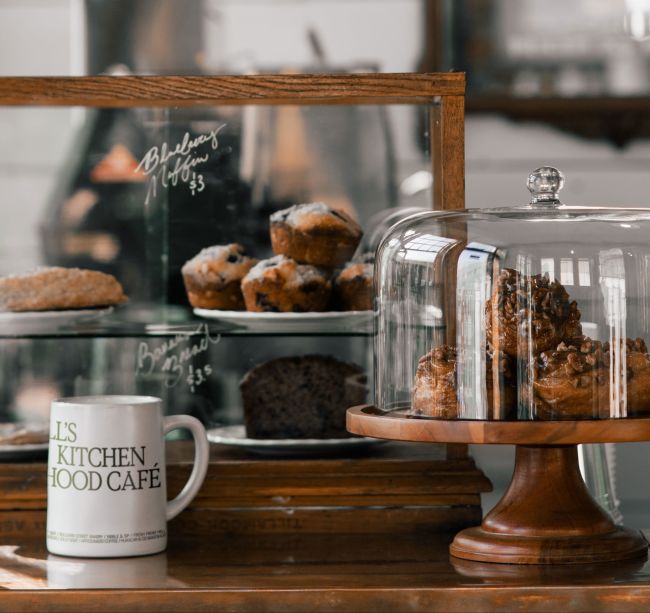 A Glass Case With A Cup Of Coffee And Pastries