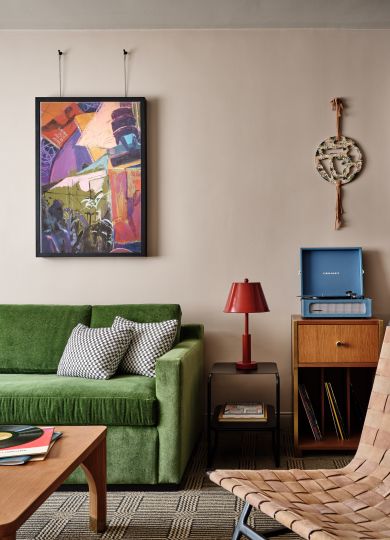 A Living Room With A Green Couch And A Television