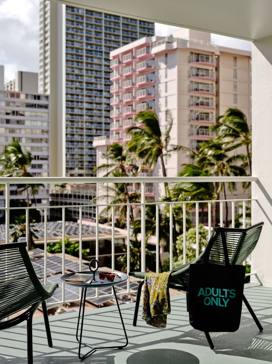 A Patio With A Table And Chairs And A View Of A City