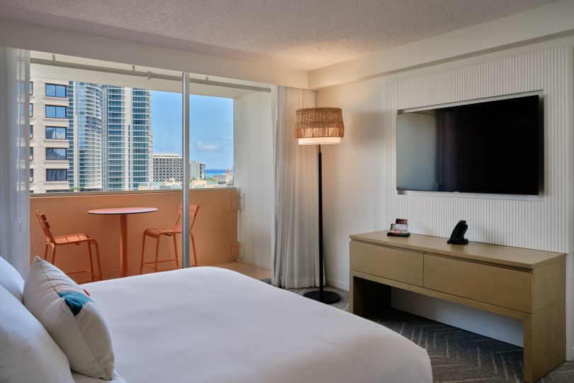 A Bedroom With A Tv And A Bed