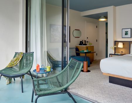 A Bedroom With A Bed And Chairs