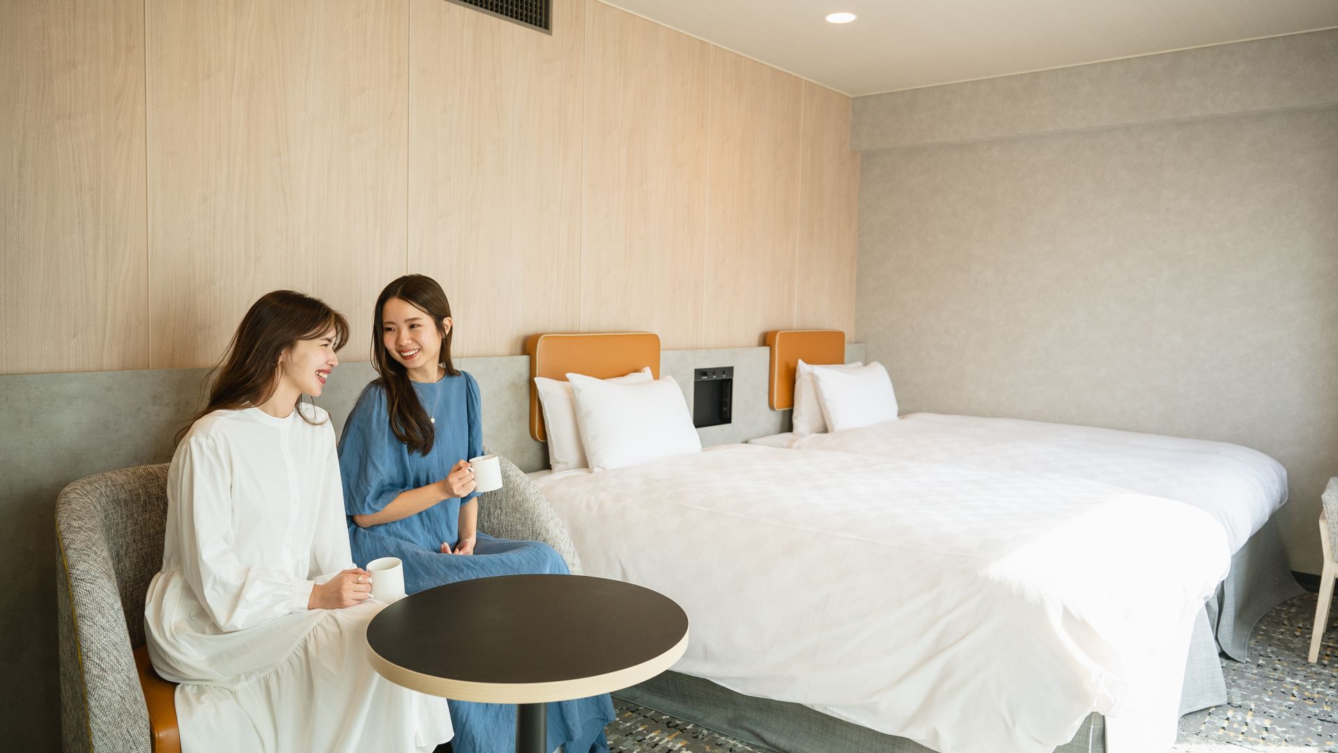 A Couple Of Women Sitting On A Couch In A Room