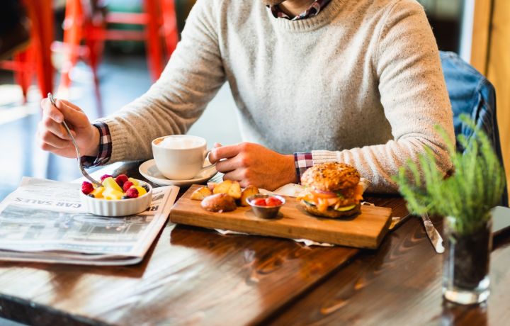 A Person Sitting At A Table With Food On It