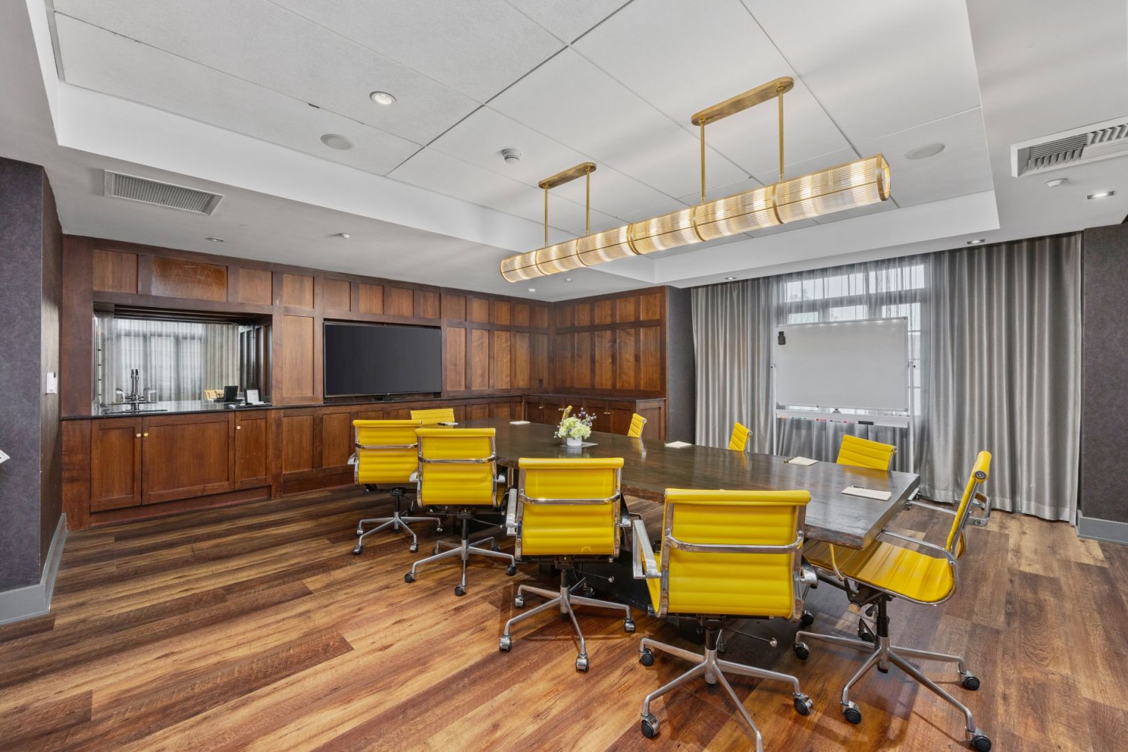 A Room With Yellow Chairs And A Tv On The Wall
