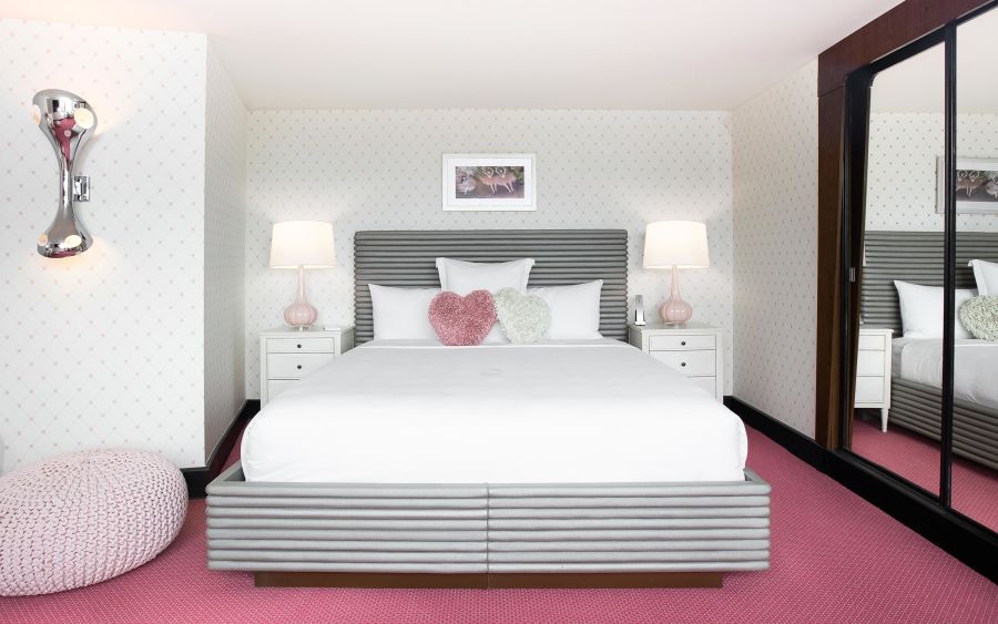 A Bedroom With A Bed And Lamps