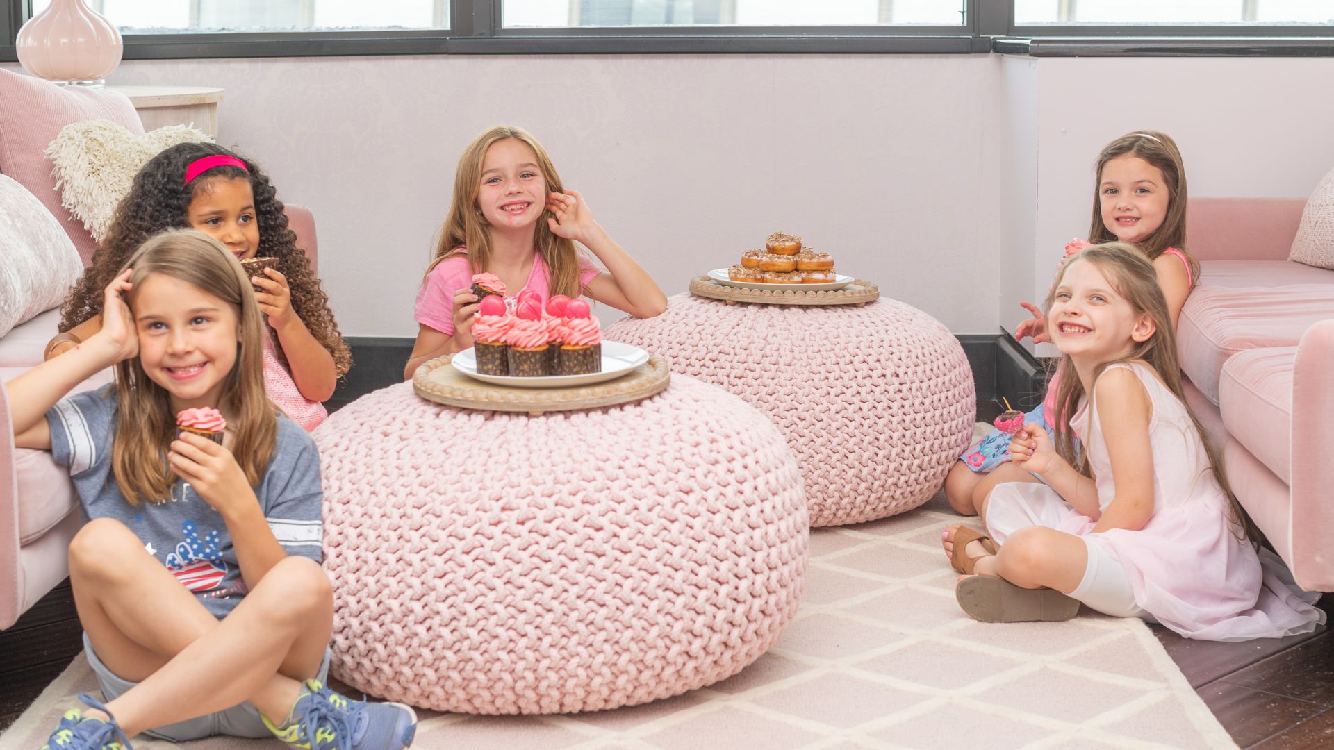 A Group Of Girls Sitting On A Couch With A Cake