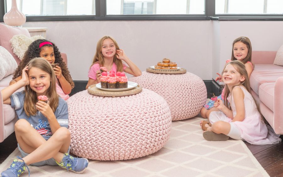 A Group Of Girls Sitting On A Couch With A Cake