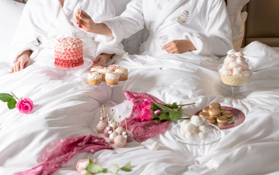 A Couple Of People In White Robes With Food On A Table