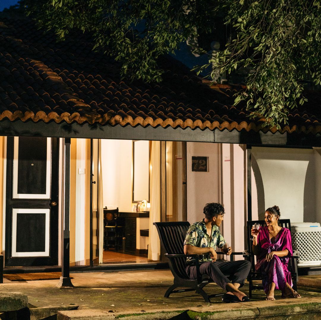 gallery-A Man And Woman Sitting On A Bench In Front Of A Building