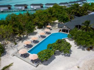 A Pool With Lounge Chairs And Umbrellas Next To A House