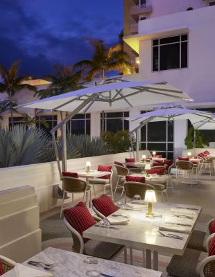 Rao's Outdoor Terrace With Tables And Chairs And Umbrellas | Loews Miami Beach Hotel