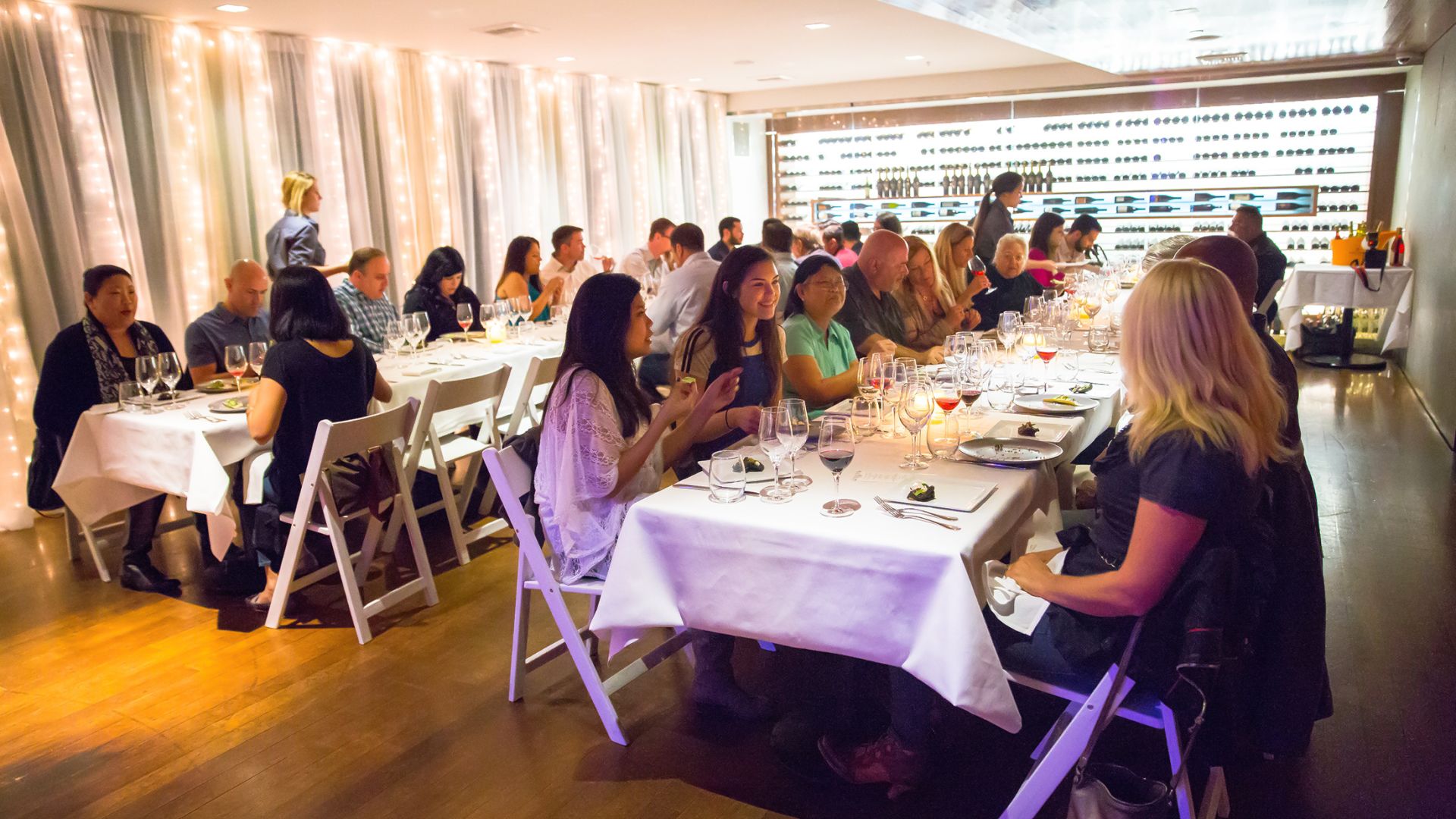 A Group Of People Sitting At Tables