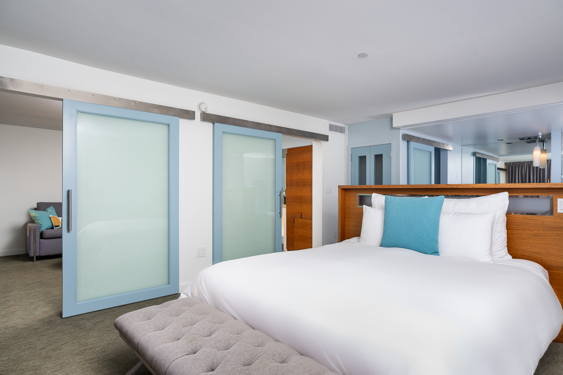 A Bedroom With A Bed And A Mirror