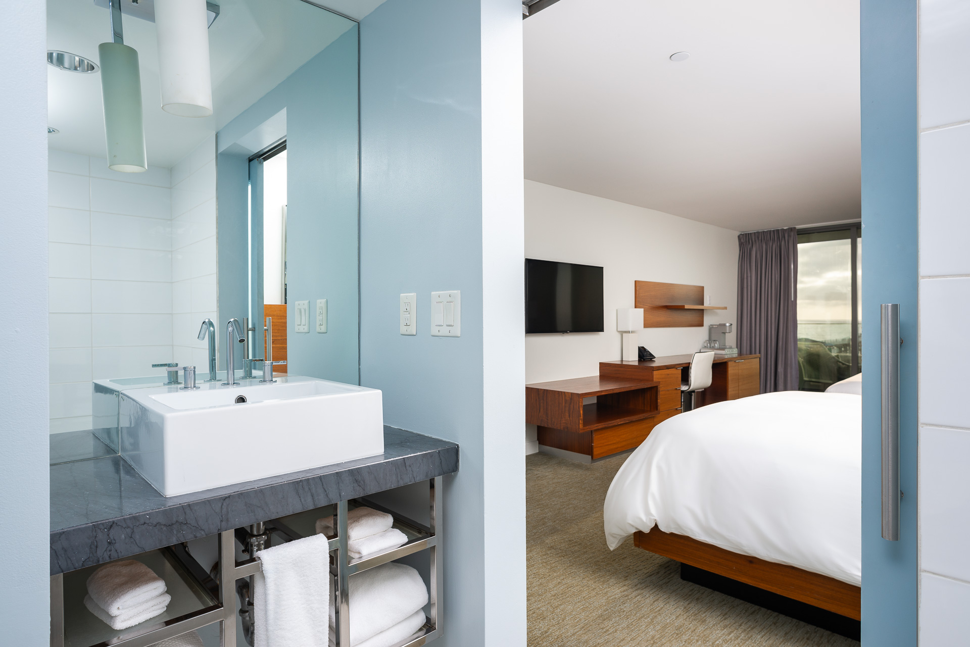 A Bathroom With A Bed And Sink